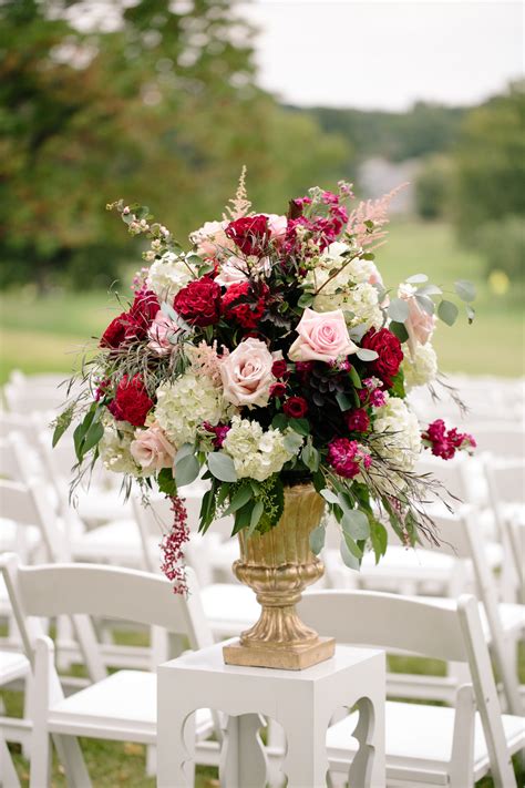 Gold Pedestal Ceremony Arrangement With Pink Roses And Red Ranunculus