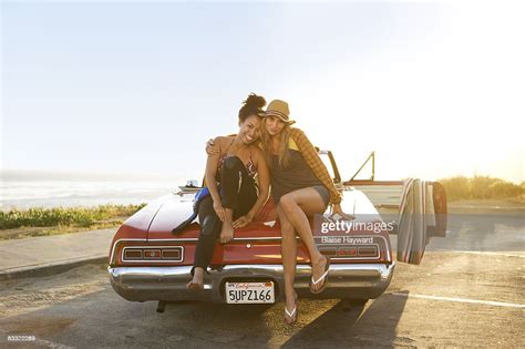 Two Girls Sitting On A Car Foto De Stock Getty Images