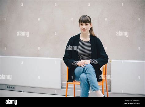 Portrait Of Confident Female Computer Programmer Sitting On Chair