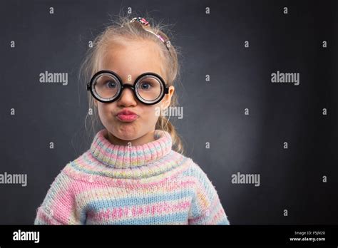 Little Nerd Girl In Glasses Makes Faces Over Grey Stock Photo Alamy