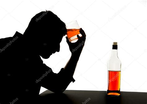 Silhouette Of Alcoholic Drunk Man Holding Whiskey Bottle Against