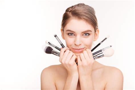 Portrait Of Attractive Smiling Woman With Brushes For Makeup Looking At
