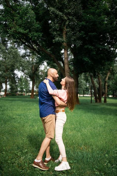 Full Length Portrait Of Happy Couple Embracing In The Garden Loving Couple Hugging Outdoors