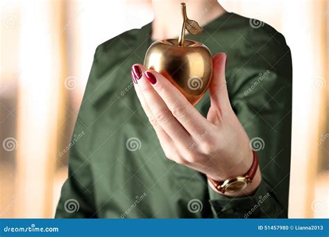 Businesswoman Standing And Holding Golden Apple In Her Hand Stock