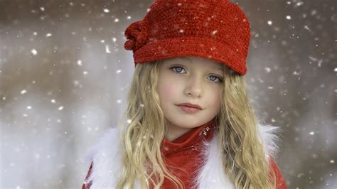 Cute Little Girl Is Wearing Red Dress And Knit Wool Cap In A Snowy