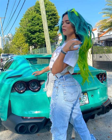 A Woman With Green Hair Standing Next To A Car