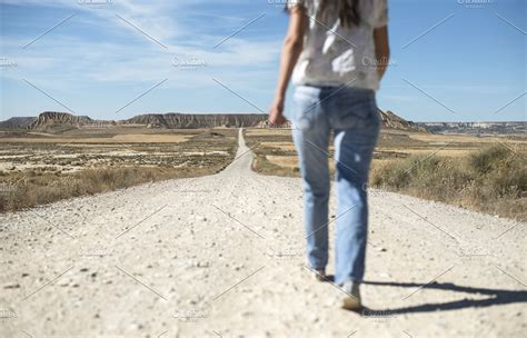 Woman Walking On Dirt Road High Quality Nature Stock Photos