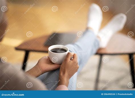 Closeup Of Young Black Woman Warming Her Hands On Cup Of Coffee