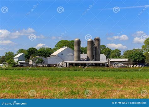 Farm With Barns And Equipment In Early Spring With Trees Still Bare Of