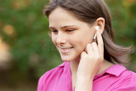 Portrait Of Lovely Girl In Pink Listening To Music Through Wireless