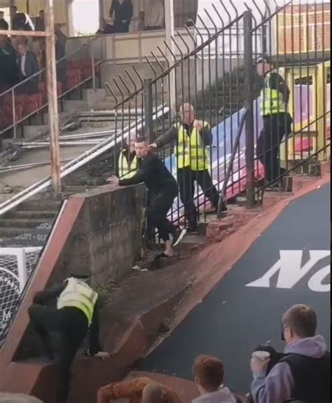 moment celtic fan climbs 20ft wall to taunt rivals then throws flares during tannadice title