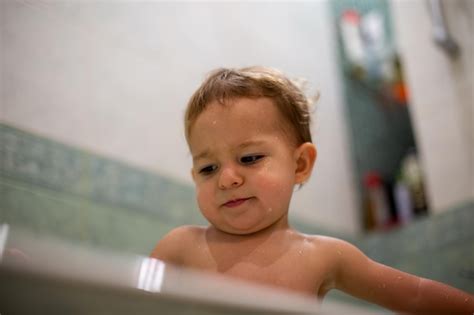 Premium Photo Low Angle View Of Shirtless Baby Girl Sitting In Bathtub
