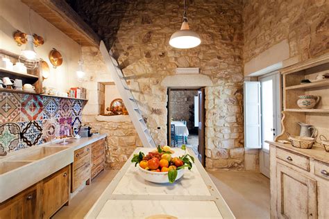 The traditional italian kitchen design feels rustic. The characterful kitchen of Masseria d'Estia, with its beautiful Sicilian ceramics. Photography ...