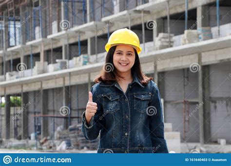 Female Civil Engineer Or Architect With Yellow Helmet Standing And