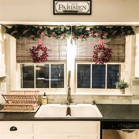 Here, the symmetry of the hood range zone is emphasized with windows on each side and wreaths strung up on the sconces above. DIY Christmas Decor Above Kitchen Sink Christmas Decor - Shower Curtain rod wrap… | Christmas ...