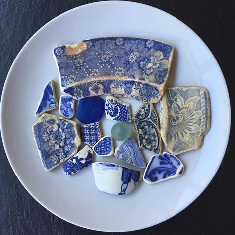 A White Plate Topped With Lots Of Blue And White Pieces Of Pottery On