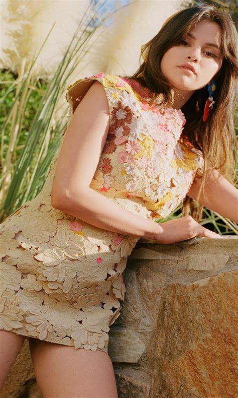Selena Gomez Is Standing Near Stone Wall Wearing Flowers Printed Dress