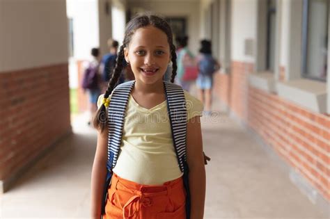 Portrait Of Happy Caucasian Elementary Schoolgirl Standing In Corridor