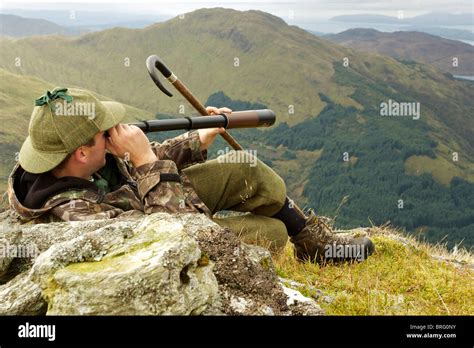 Scottish Deer Stalker Spying For Deer Using A Three Draw Telescope