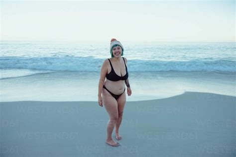 Carefree Winter Bather Smiling At The Camera While Standing Alone At The Beach Happy Middle