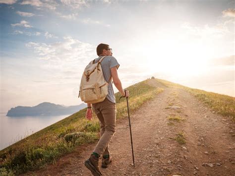 Young Man Travels Alone On The Backdrop Of The Mountains Stock Photo