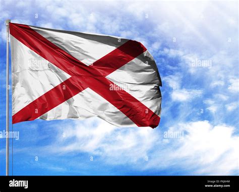 Flag State Of Alabama On A Flagpole In Front Of Blue Sky Stock Photo