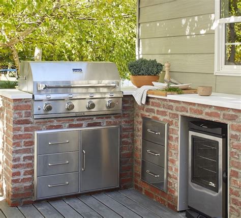 An Outdoor Kitchen With Grill Sink And Oven