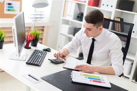 Premium Photo A Young Man Sitting At A Computer Desk In The Office