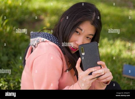 Lifestyle Portrait Of Young Happy And Beautiful Asian Korean Woman In Pink Hoodie Enjoying With