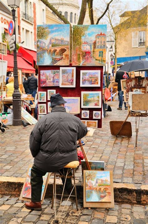 Public Painter With His Paintings In Place Du Tertre Square In Paris