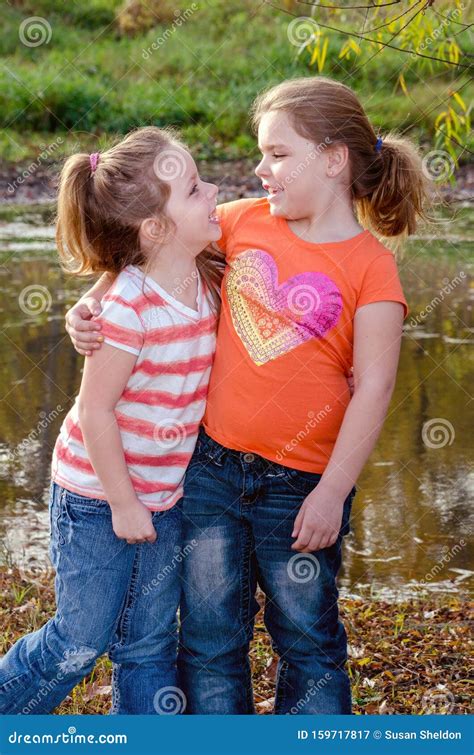 Two Sister Hug As They Pose For A Photo Outdoors Stock Image Image Of