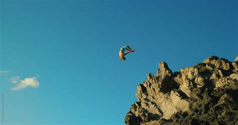 Young Man Cliff Jumping At Sunset By Stocksy Contributor Ama Mas Stocksy