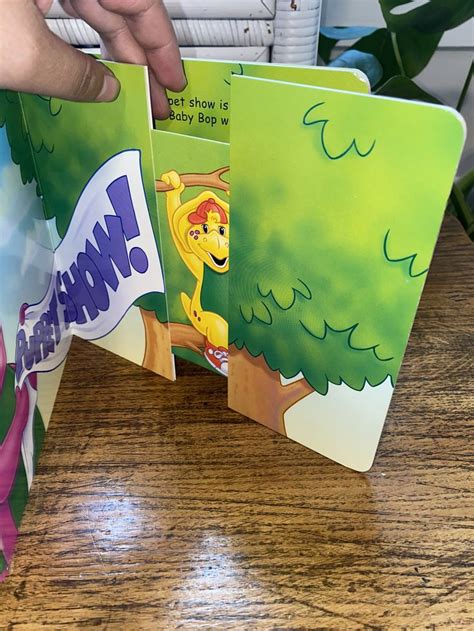 A Person Holding Up Two Childrens Books On A Table