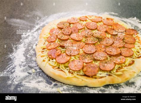 Preparing pepperoni pizza on black granite table Stock Photo - Alamy