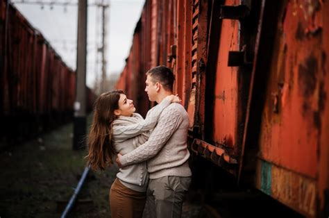 Premium Photo Young Couple Wearing On Tied Warm Sweaters Hugging In Love At Railway Stations