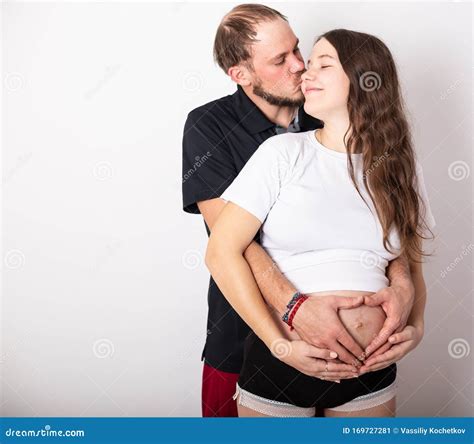 Cropped Image Of Beautiful Pregnant Woman And Her Handsome Husband Hugging The Tummy Stock Image