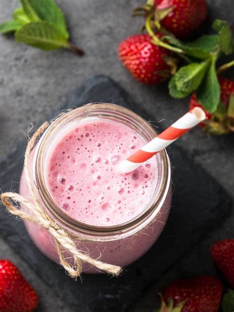A Pink Smoothie In A Mason Jar With Strawberries On The Side And One