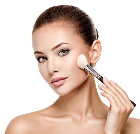 Woman Applying Cosmetic Makeup On The Face With Brush Stock Photo