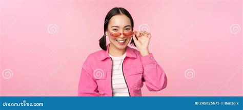 eyewear advertisement stylish modern asian girl touches sunglasses wears pink poses against