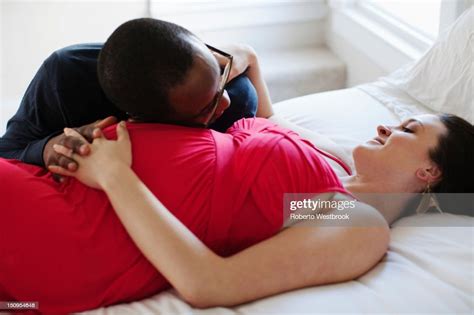 Husband Laying On Bed With Pregnant Wife Photo Getty Images