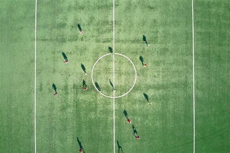 Aerial View Of Soccer Players Playing Football On Green Sports Stadium