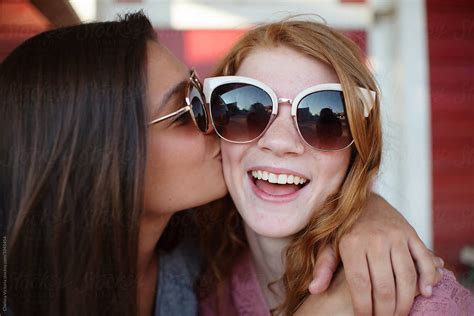 Teenage Sisters Sharing Ice Cream And Taking Selfies By Stocksy
