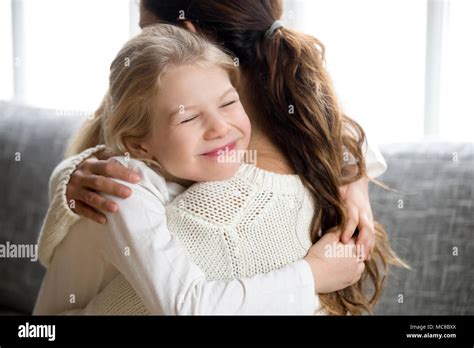 Cute Little Daughter Hugging Mother Holding Tight Mum And Happy Preschool Or School Girl