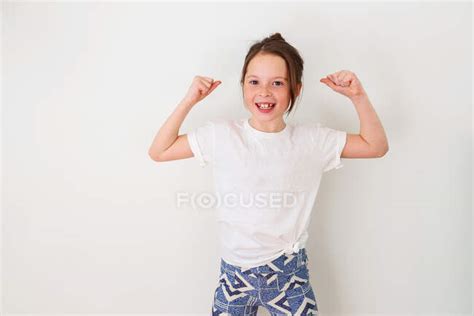 Girl Standing By A Wall Flexing Her Muscles — Strong Day Stock Photo