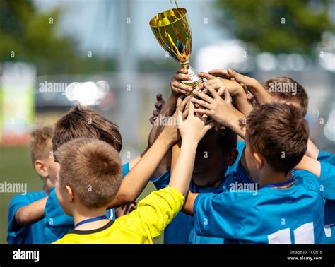 Happy Sports Soccer Team Raising Trophy Winners Of Youth Football