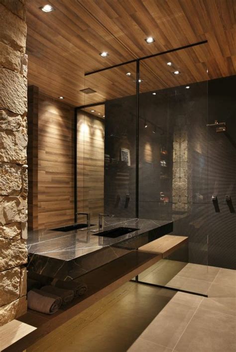 A Modern Bathroom With Stone Walls And Flooring Is Pictured In This
