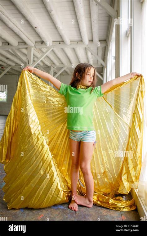 Barfuß Mädchen In Badeanzug Und Gold Umhang Steht In Großen Leeren Raum Stockfotografie Alamy