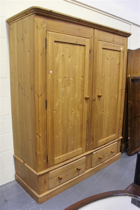 A Modern Pine Wardrobe Fitted With Two Panelled Doors And Two Drawers