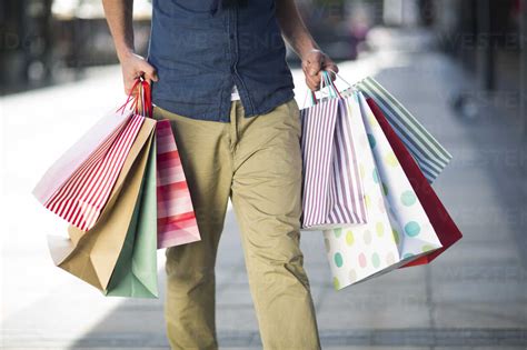 Man Carrying Lots Of Shopping Bags Stock Photo