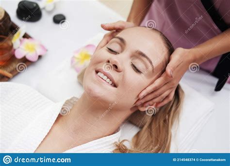 asian massage therapist woman is making traditional head and facial treatment massage to